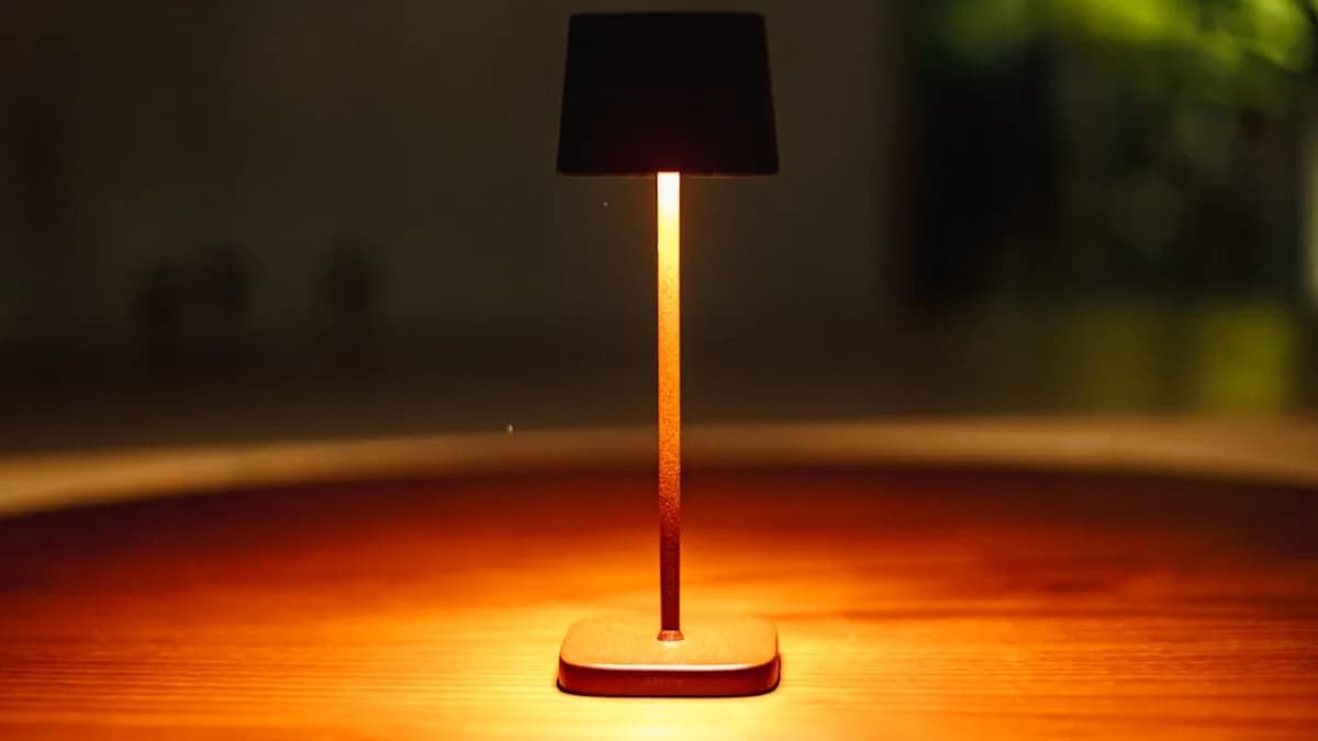 A small lamp illuminates a wooden table.