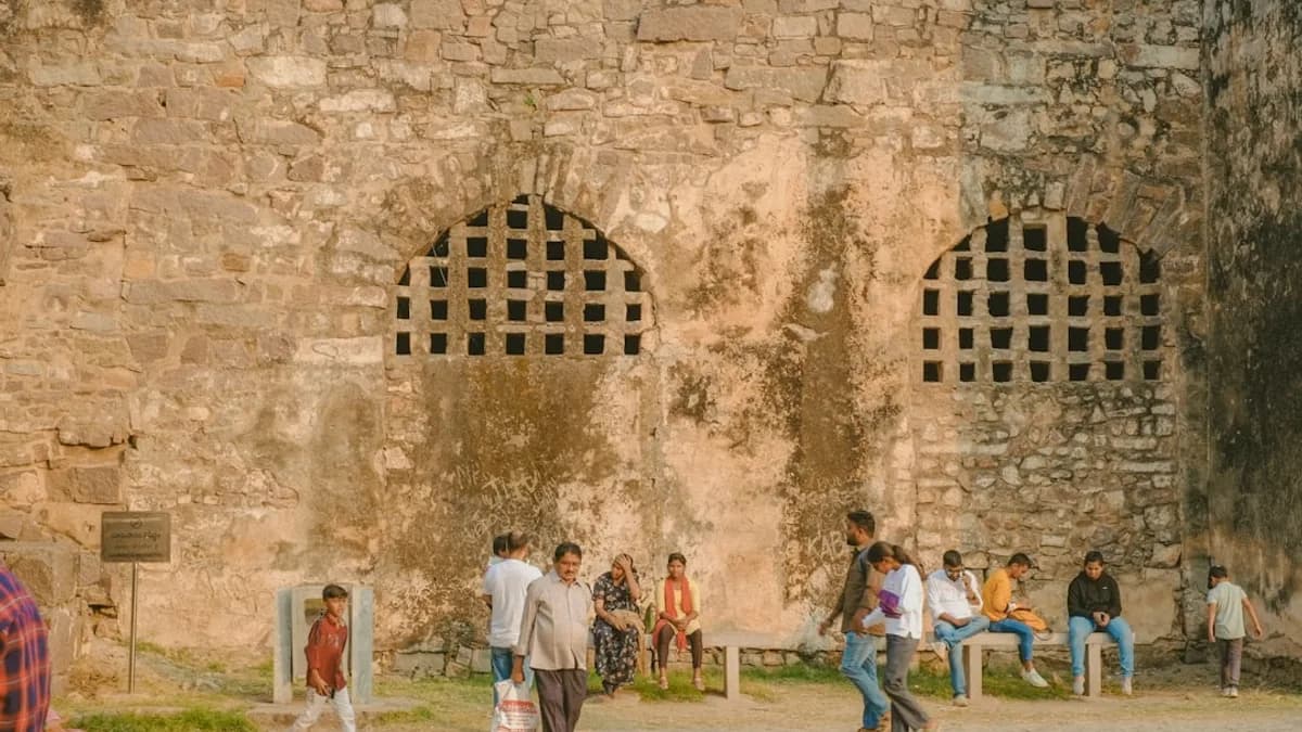 a group of people standing around a stone building