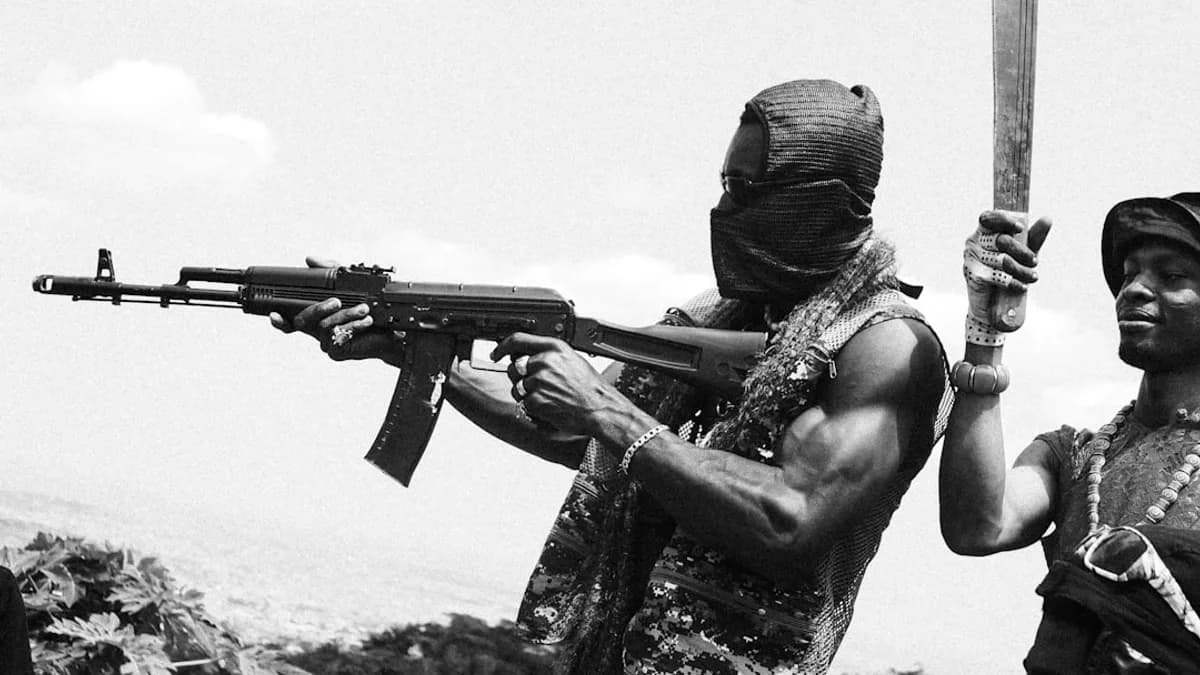 a man holding a rifle next to another man