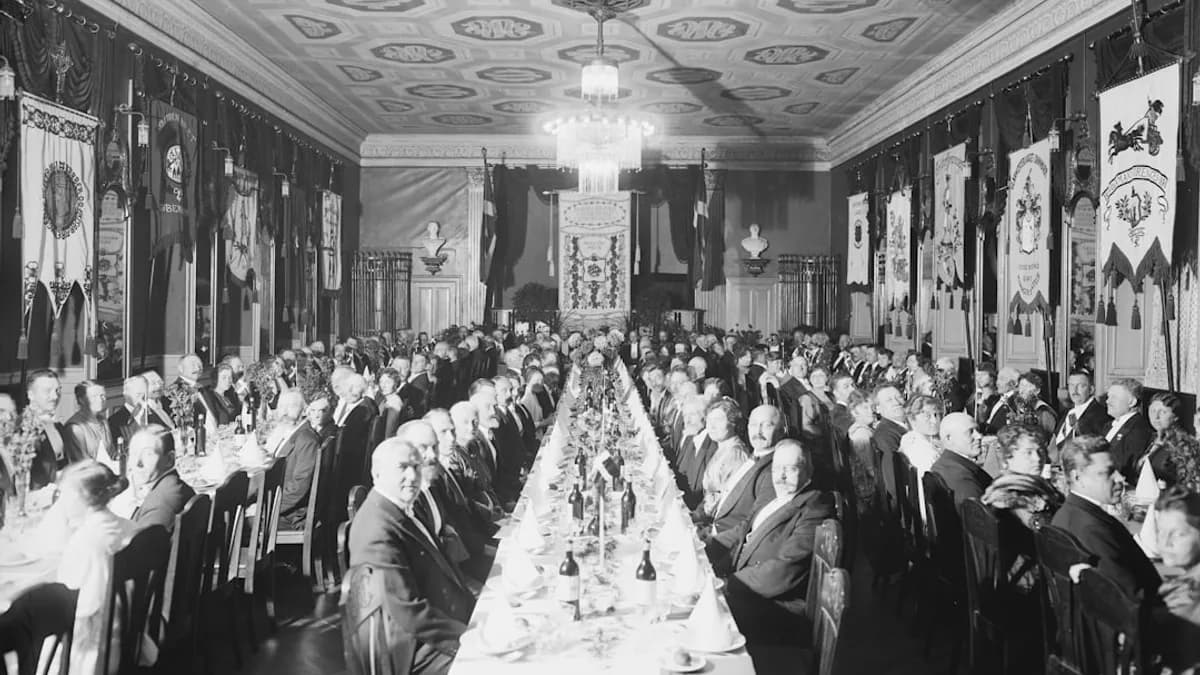 a large group of people sitting at a long table