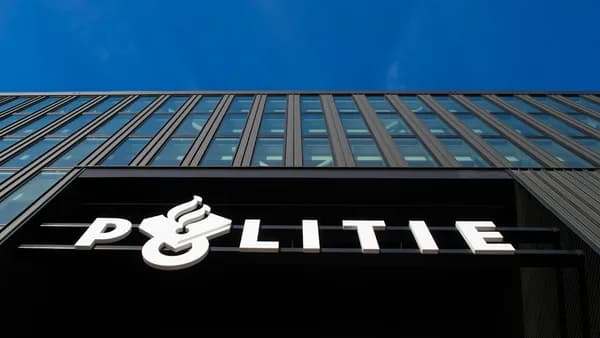 Modern building with "politie" sign under blue sky