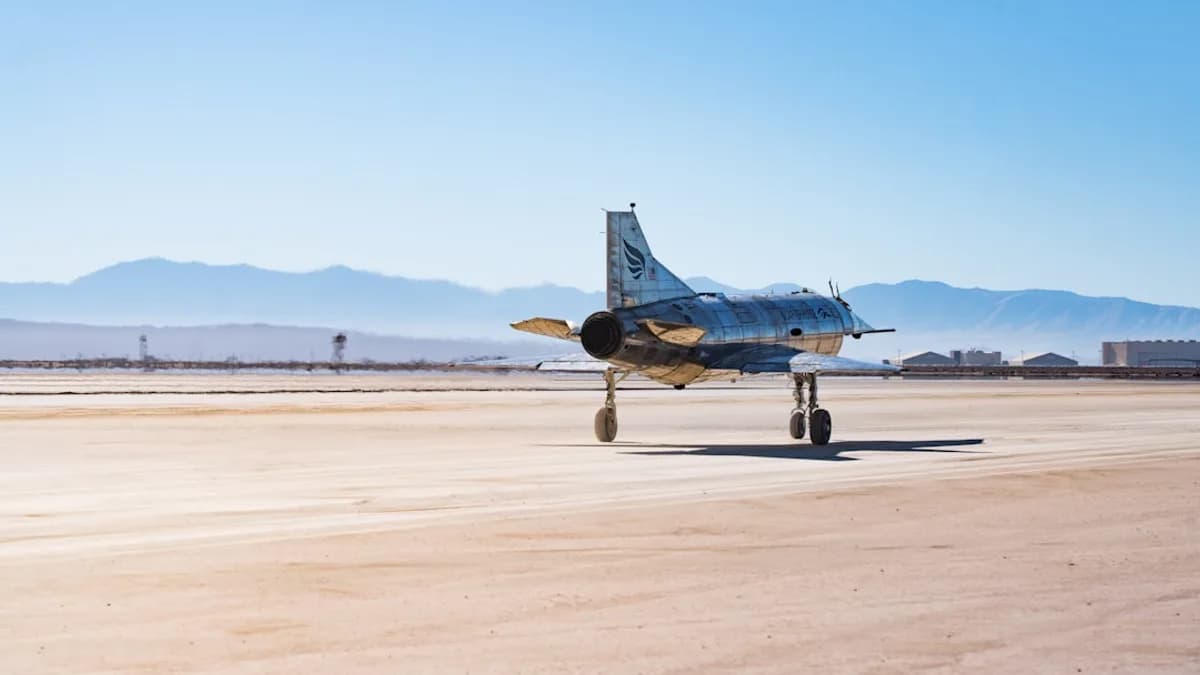 A fighter jet sits on a desert runway.