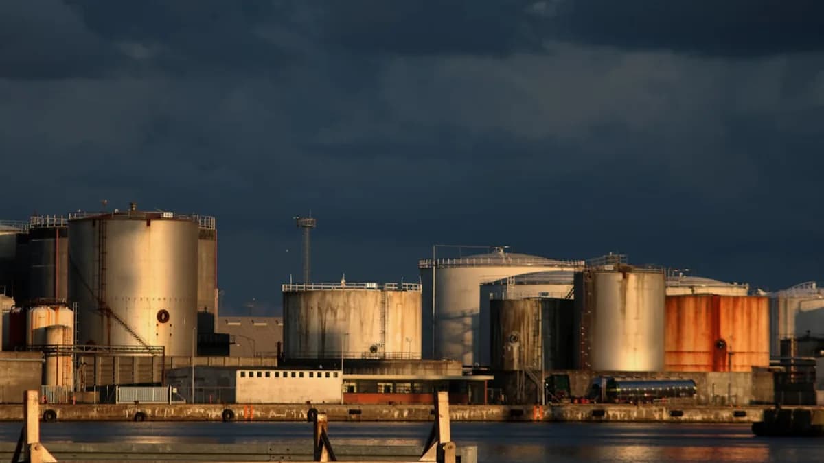 a large industrial area with a body of water in front of it