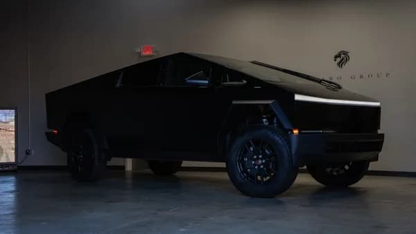 A black futuristic electric truck parked indoors.