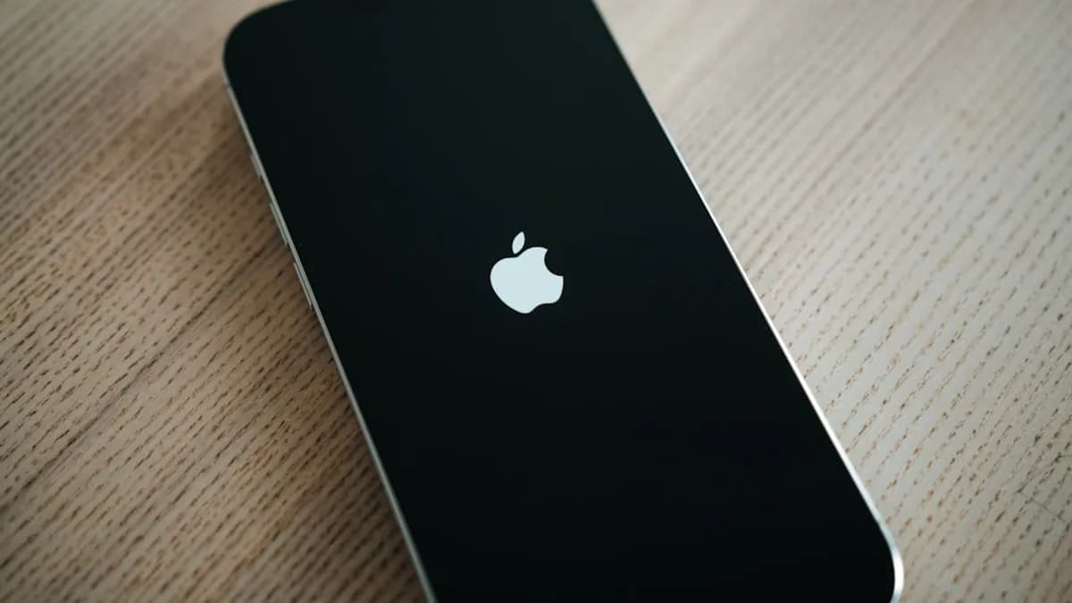 A black iPhone sitting on top of a wooden table