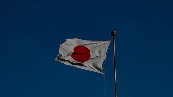 A flag flying in the wind with a blue sky in the background