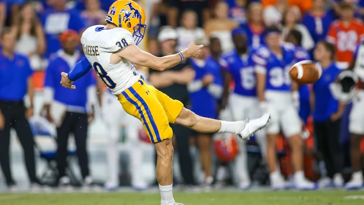 a man kicking a football on top of a field