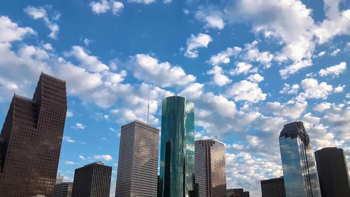 a view of a city with skyscrapers and clouds in the sky