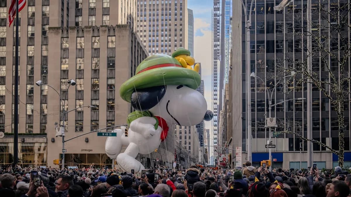 Snoopy balloon floats down a city street parade.
