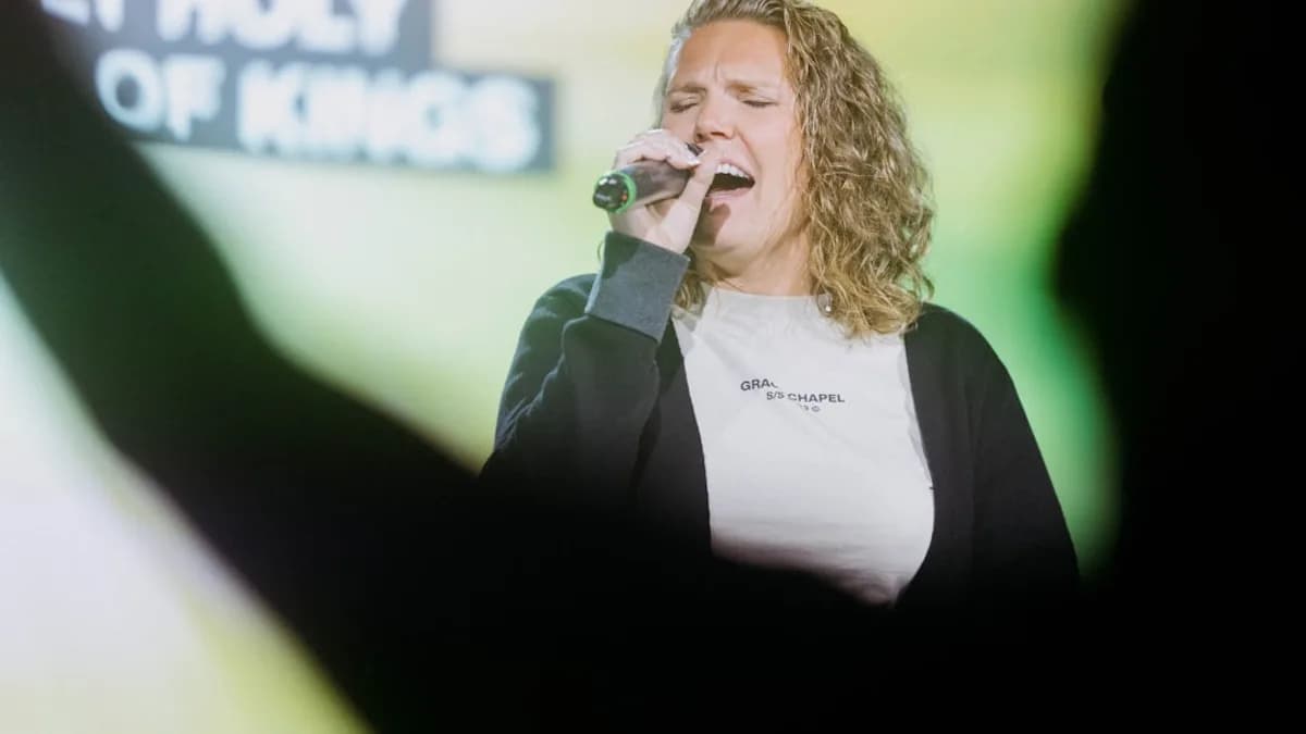 a woman singing into a microphone on stage