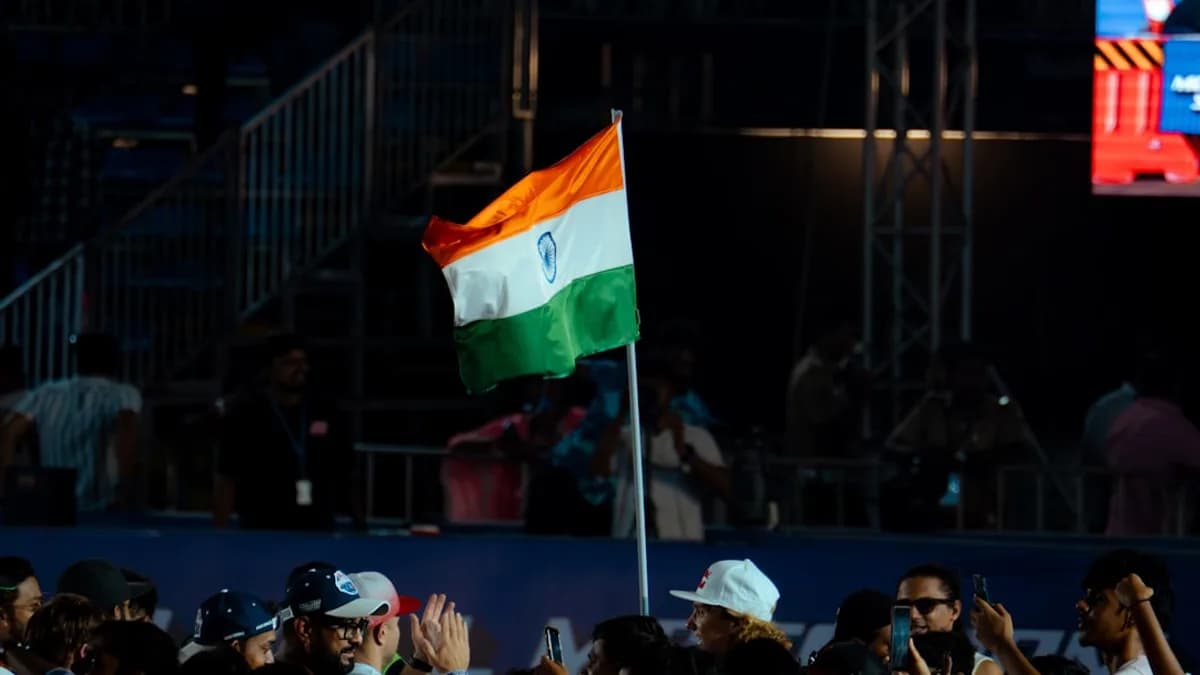 The indian flag waves above a crowd.