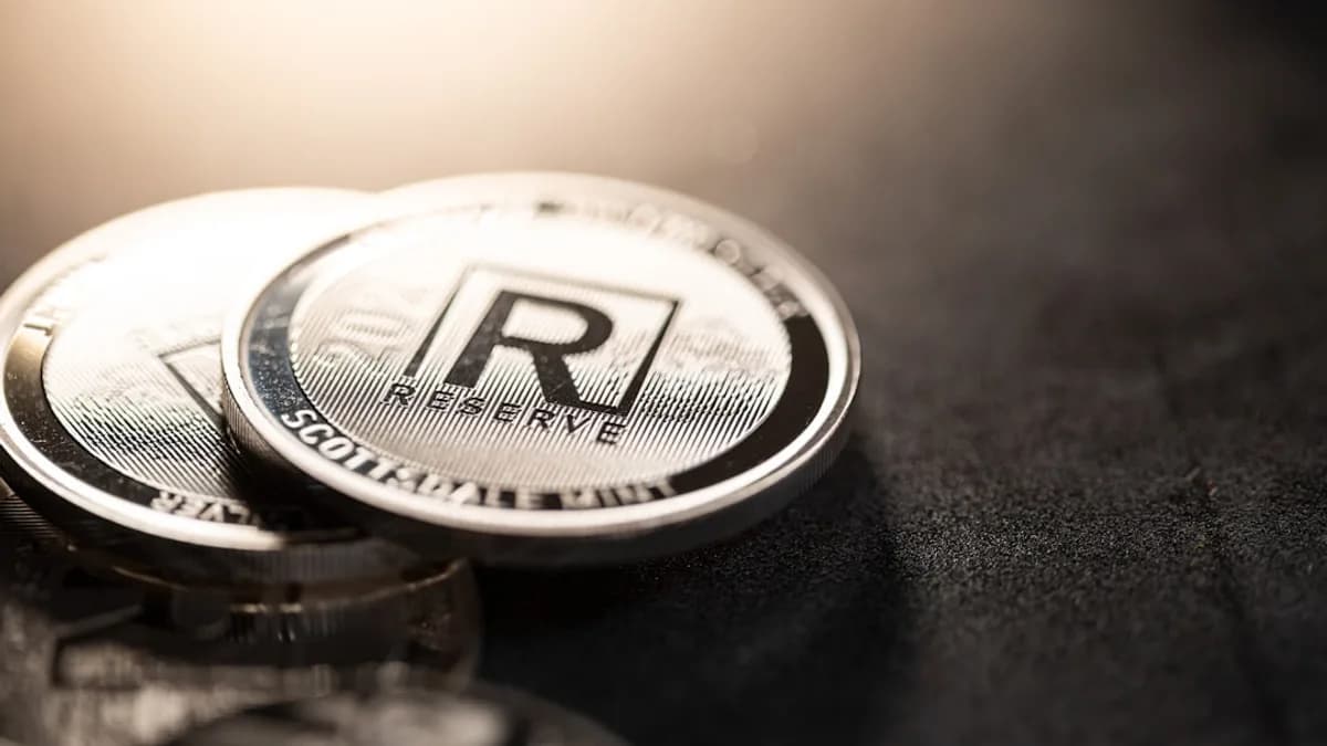 a close up of two silver coin on a black surface