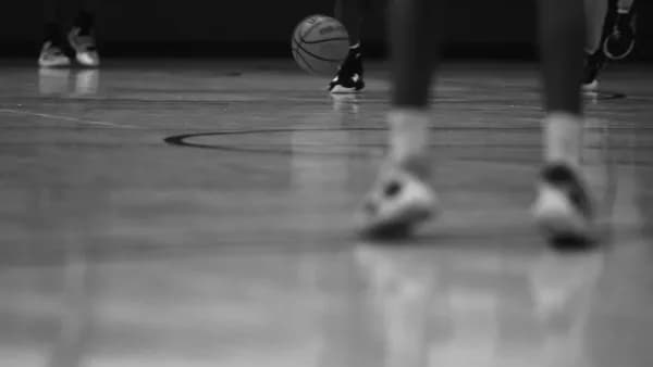 a group of people standing on top of a basketball court