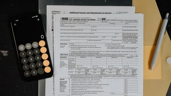 Tax forms and calculator on a desk.