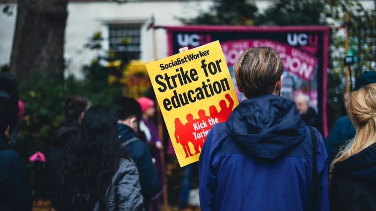 a group of people holding a strike for education sign