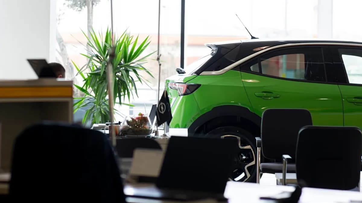 A green car is parked in an office