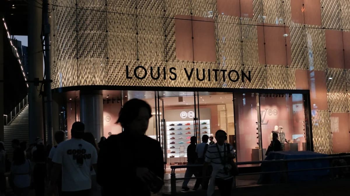 Louis vuitton store exterior at night with people.
