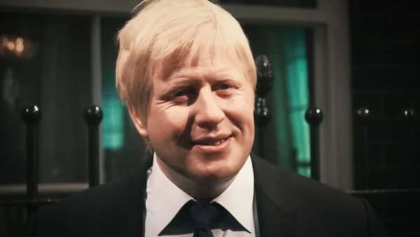 a close up of a person wearing a suit and tie