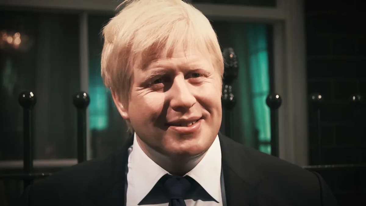 a close up of a person wearing a suit and tie