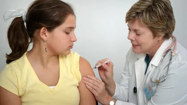 woman injecting girl's left arm