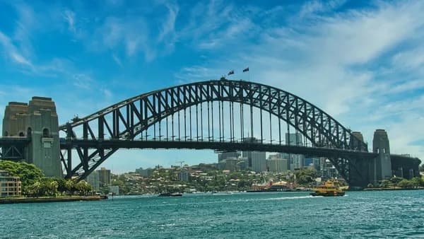 Sydney harbour bridge under a bright blue sky.