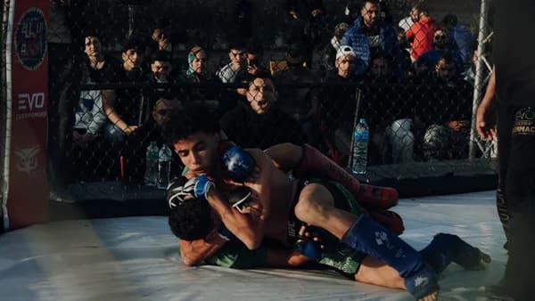 A group of people standing around a wrestling ring