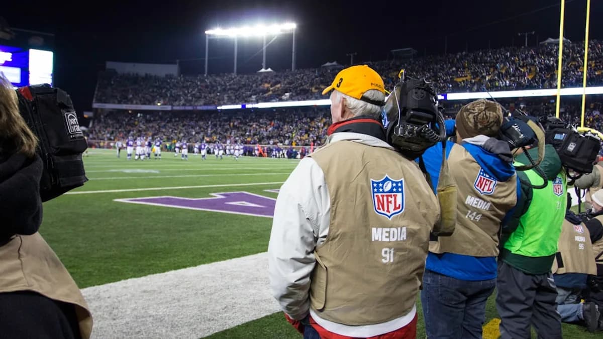 people standing and watching NFL game in green field