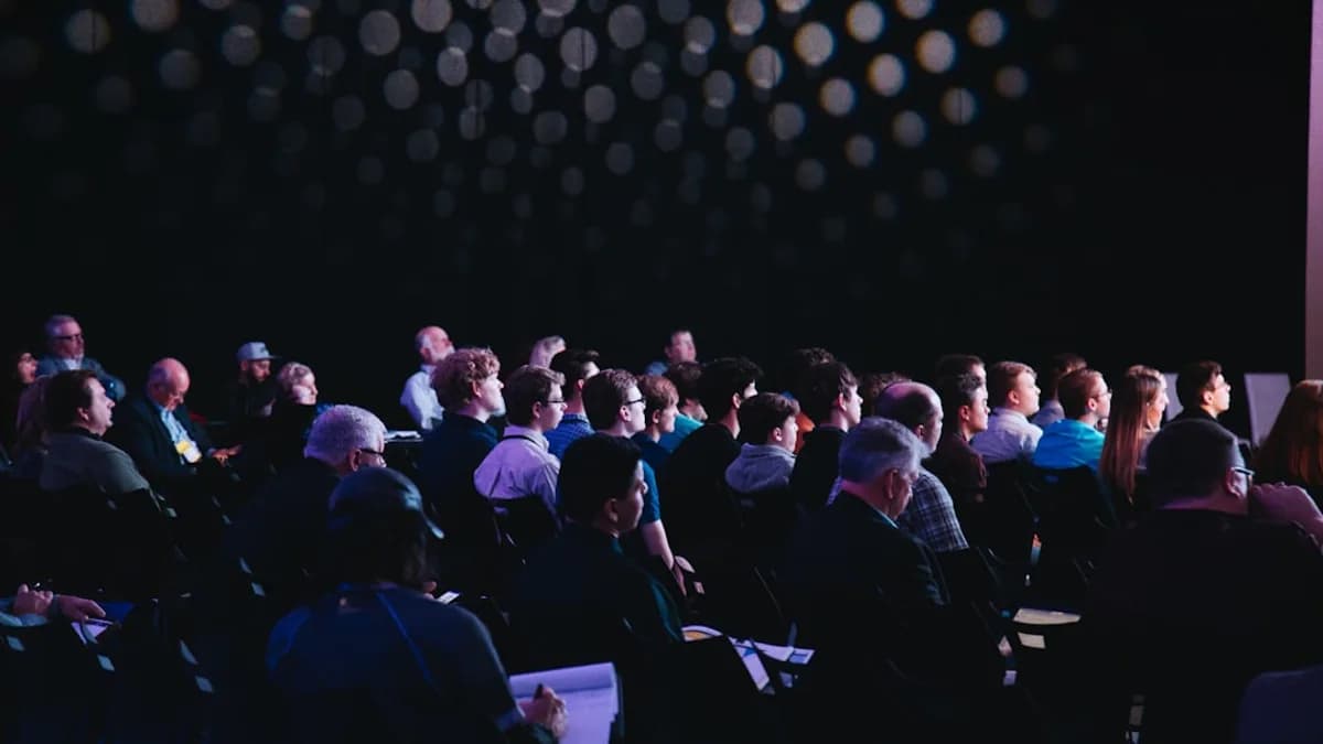 crowd of people sitting on chairs inside room