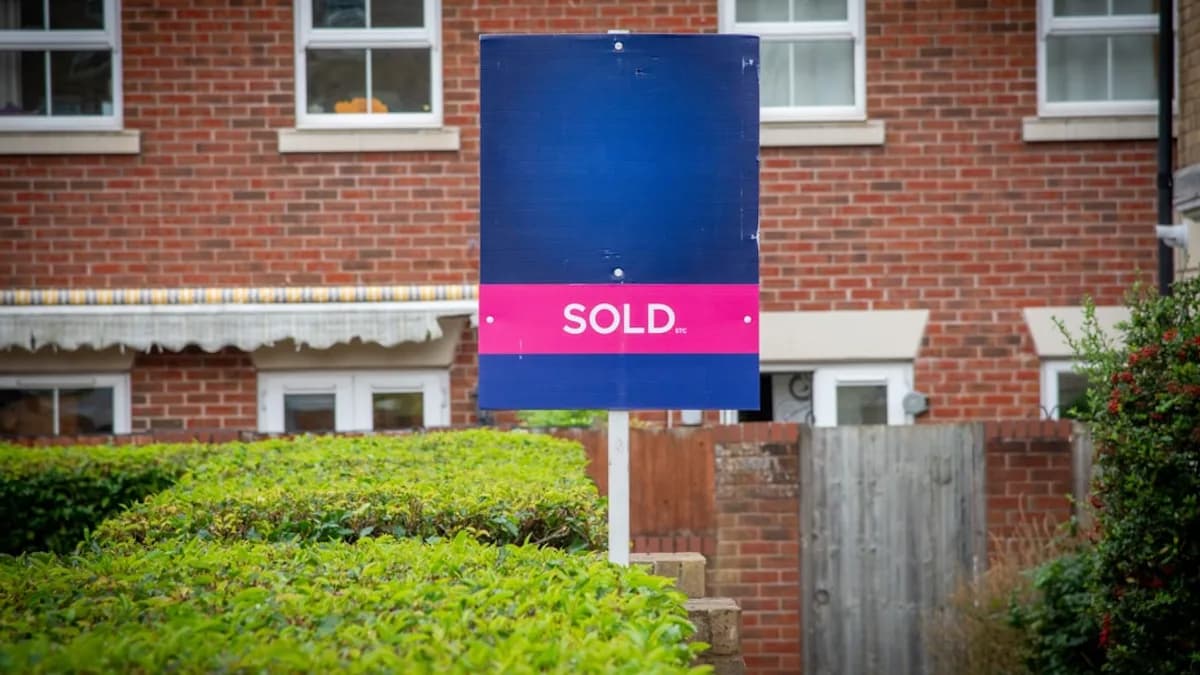 A sold sign in front of a brick building