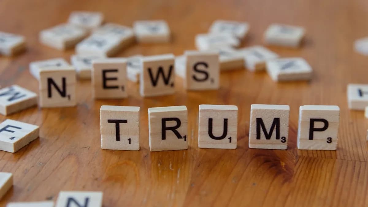 A wooden table topped with scrabble letters spelling news, trump