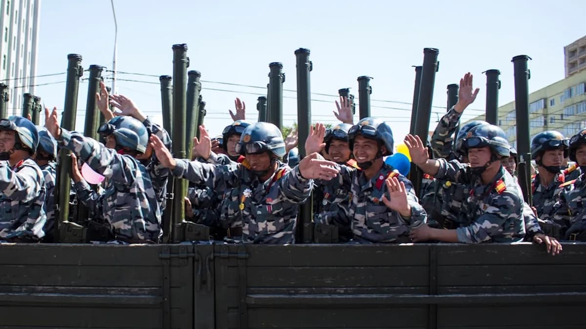 soldiers in brown and black camouflage uniform sitting on black metal frame during daytime