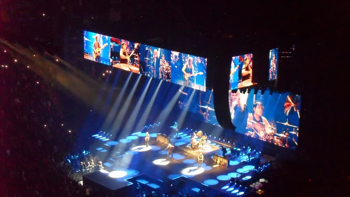 Live band performing on a brightly lit concert stage.