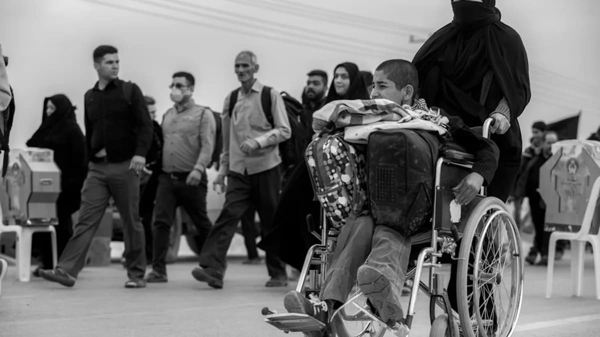 grayscale photo of boy sitting on wheelchair