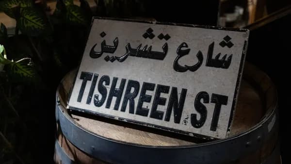 Street sign for tishreen street in arabic and english.