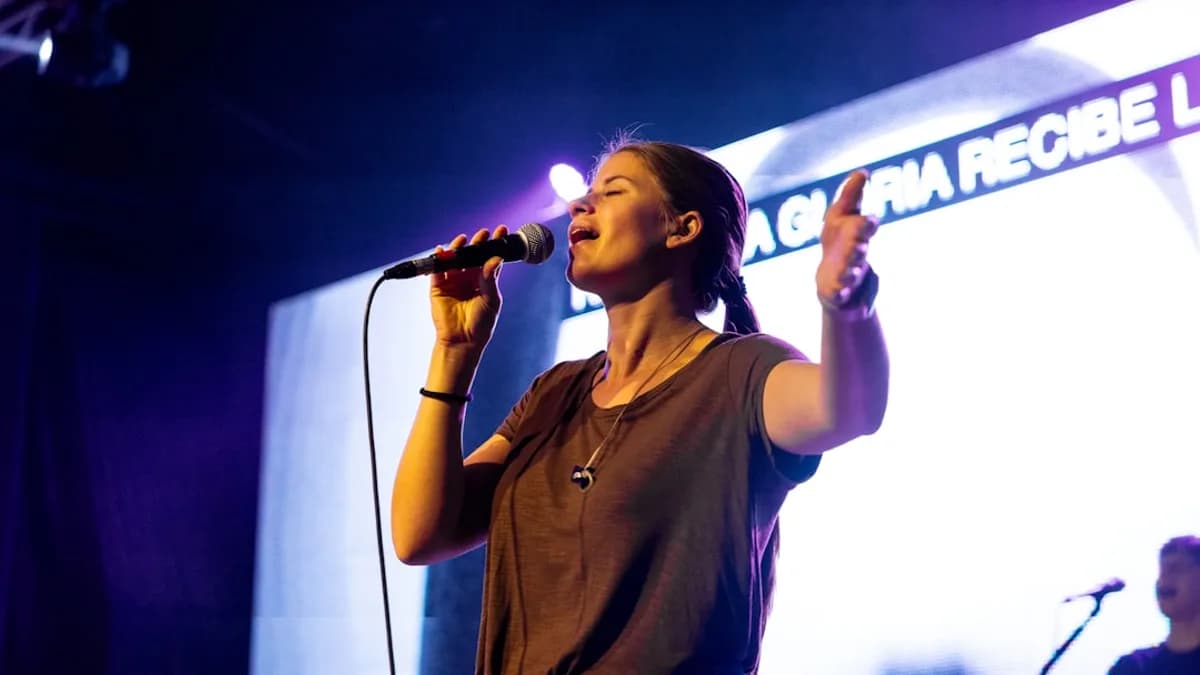 A woman singing into a microphone on stage