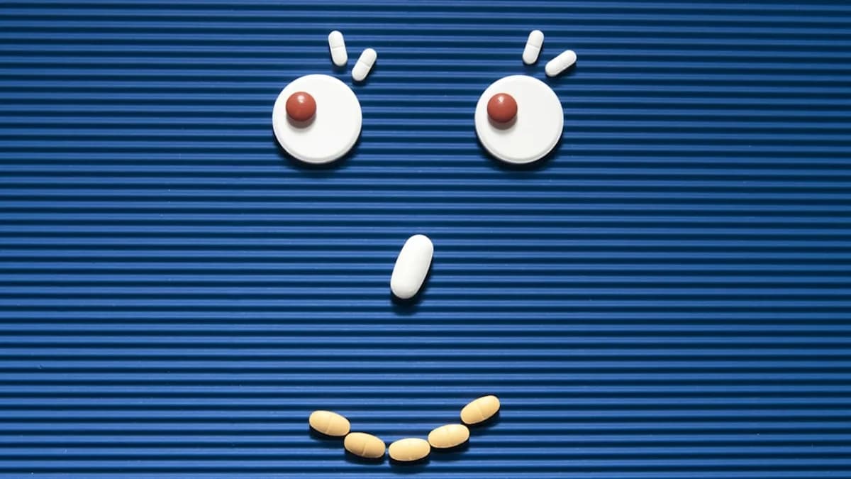 A sad face made out of pills on a blue background
