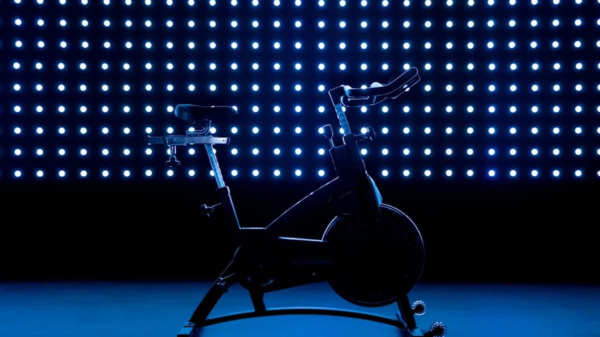 a stationary exercise bike in front of a blue background