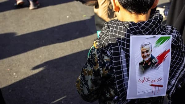 boy in black hoodie with photo of man in back