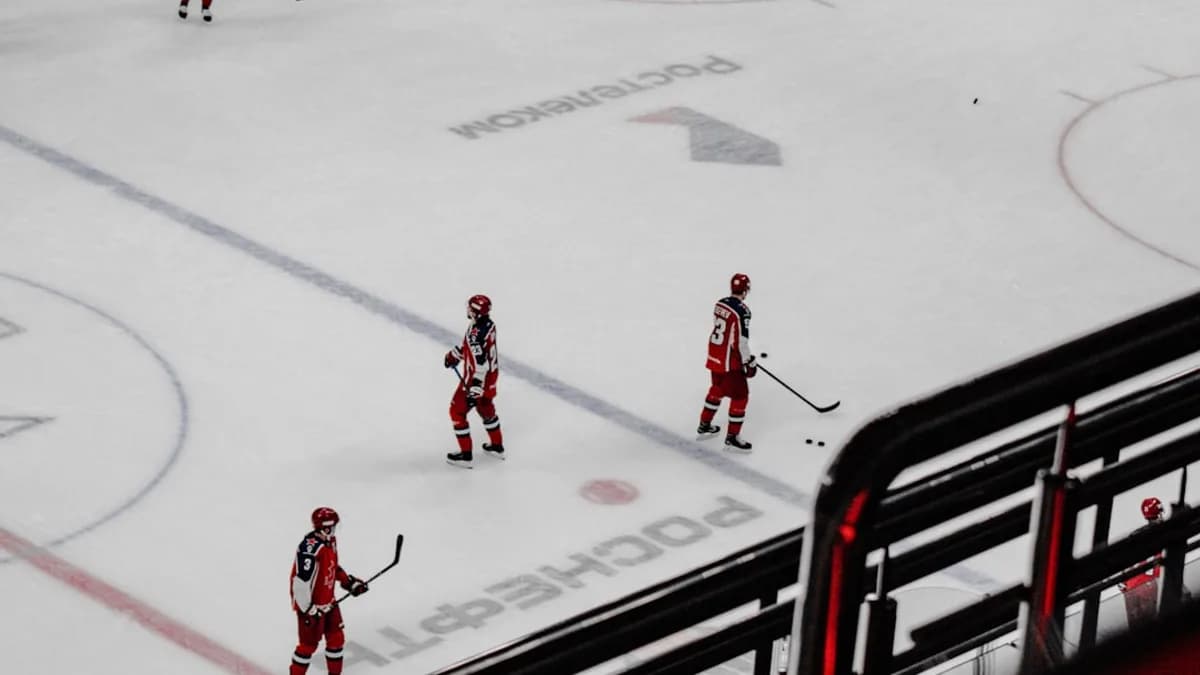 3 men in red suits walking on white snow during daytime