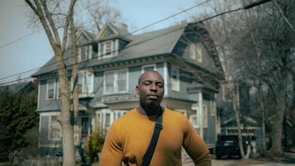 man in yellow crew neck long sleeve shirt standing near building during daytime