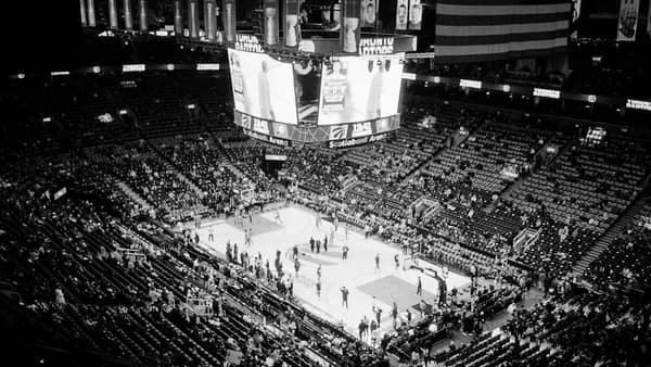 Basketball game in a packed arena at night.