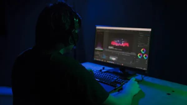 a man sitting in front of a computer in a dark room
