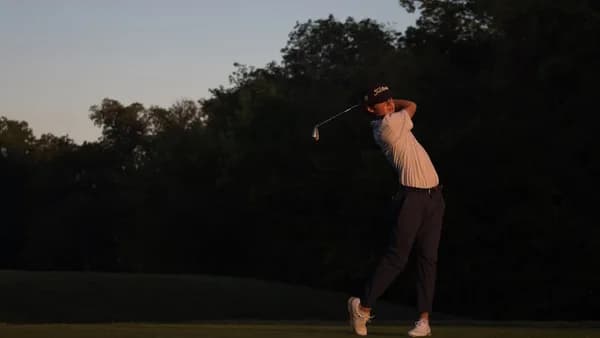 a man swinging a golf club on a golf course