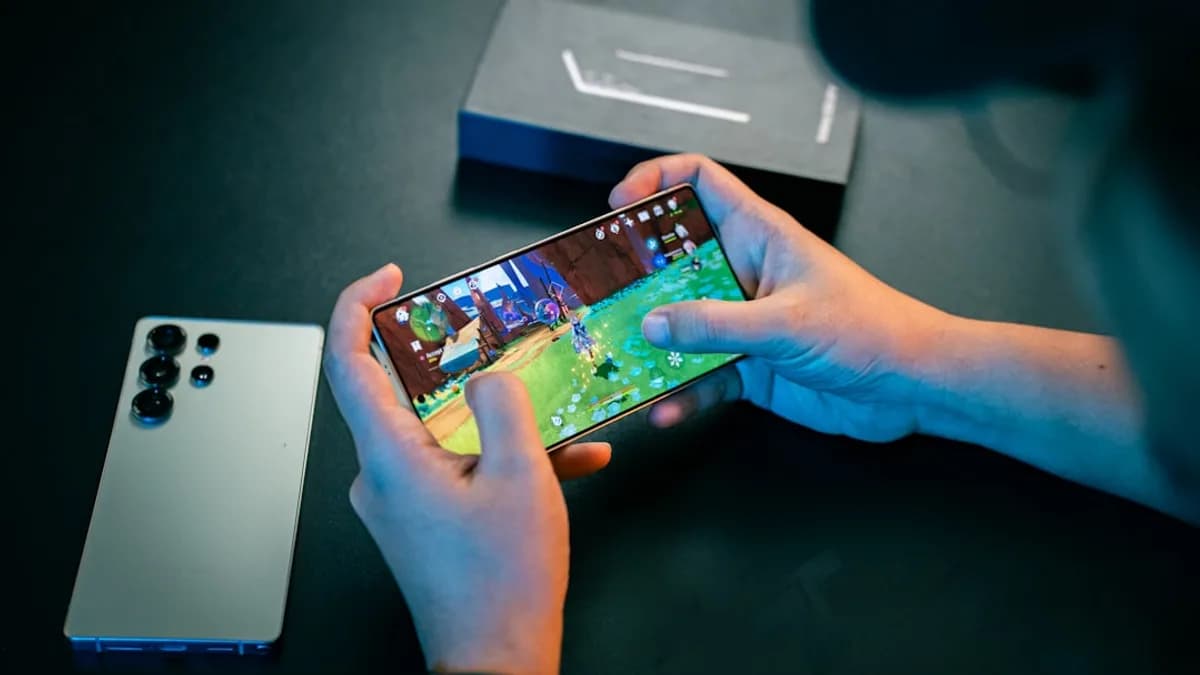 A person sitting at a table with a cell phone