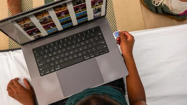 Person inserting sd card into laptop