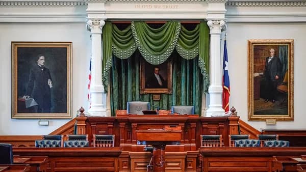 a room with a green curtain and a podium with a painting on it