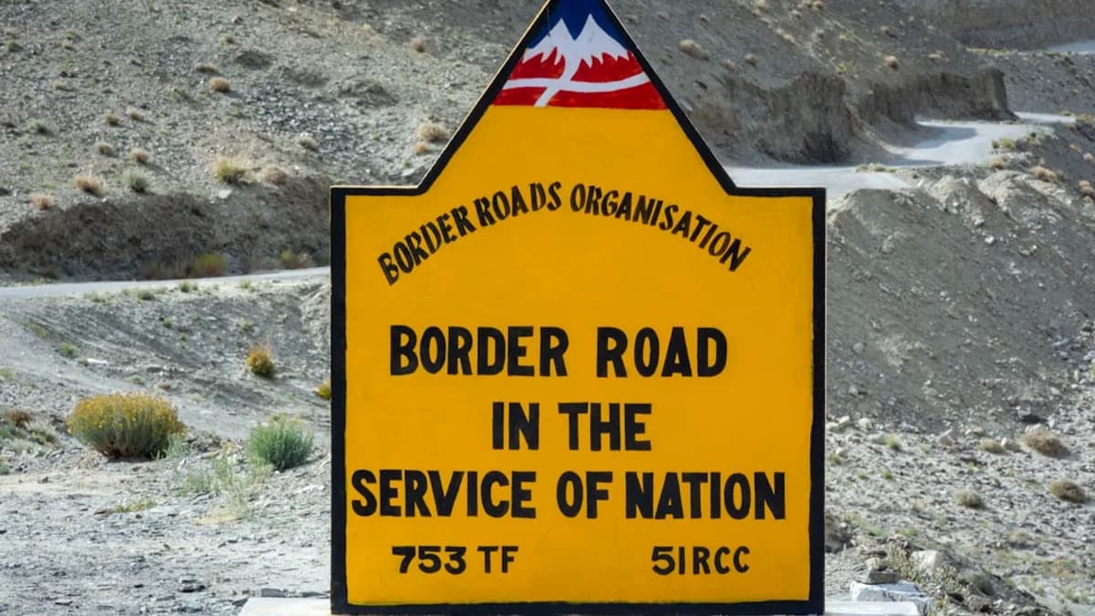 Yellow sign for border road organisation in mountains.
