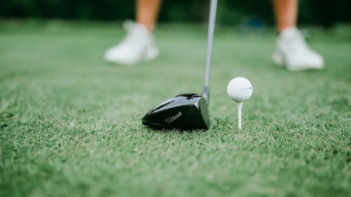 a golf club and a golf ball on the grass