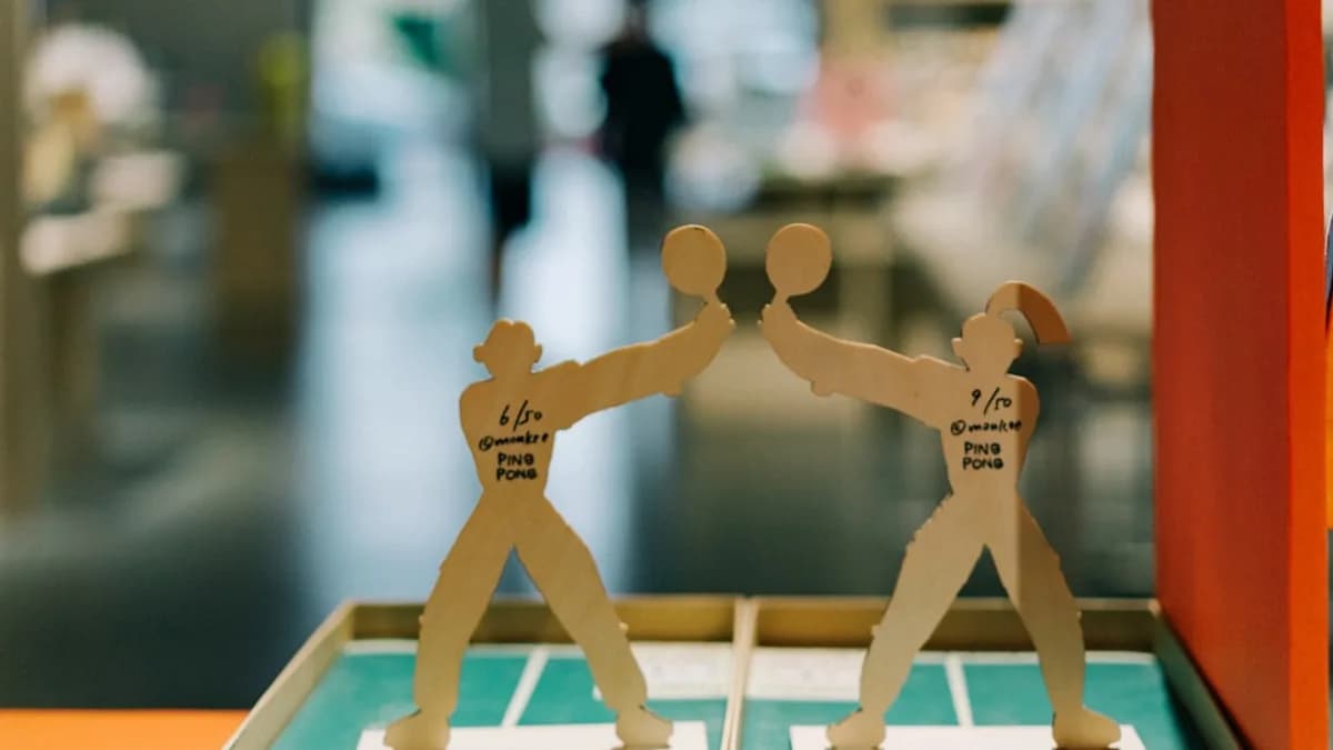 A pair of paper cutouts of two men playing tennis