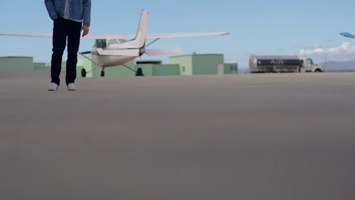 Man walking on tarmac near small airplane